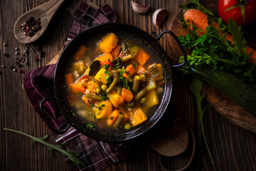 Vegetable soup with parsley on dark background