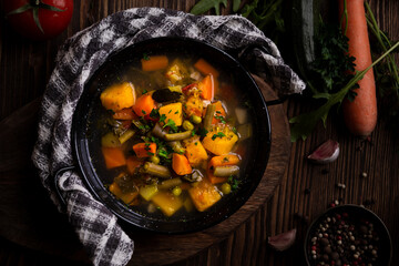 Vegetable soup with parsley on dark background
