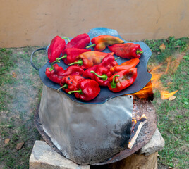 Top view of fresh red paprika being grilled on hot plate for preparation of traditional Balkan's spread ajvar