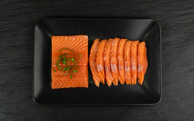 Slices of Raw Salmon Fillet on Black Background Top View