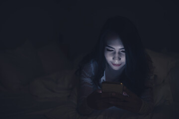 Asian woman playing game on smartphone in the bed at night,Thailand people,Addict social media