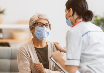 Doctor and senior woman wearing facemasks