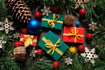 Colorful Christmas gifts and toys on the background of Christmas tree branches. Christmastime.