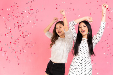 Fototapeta premium Portrait of two lovely cute asian women in christmas hats looking at camera isolated over pink background.Attractive asian woman smile in christmas, new year, valentine day, birthday .