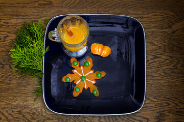 Fototapeta na wymiar Hot apple cider, cookie and orange on a square plate; festive snack with decorated cookies and orange segments