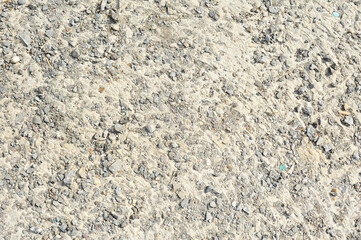 gray texture with interspersed stones,the background is grey with small stones

