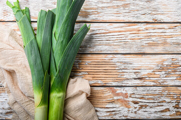 Organic Leek onion on white wooden background, top view with space for text.