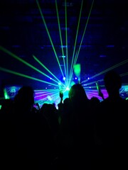 Crowd at concert : Silhouette people crowd happy and cheering with led foam stick light in front of bright colorful stage lights