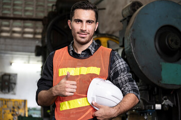 smile engineer checking and inspects quality of industrail machine in factory with confident