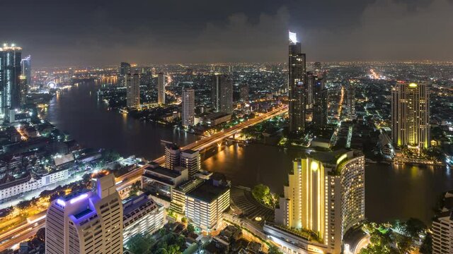 Time lapse of the Chao Phraya River and Bangkok Thailand at night with clouds overhead