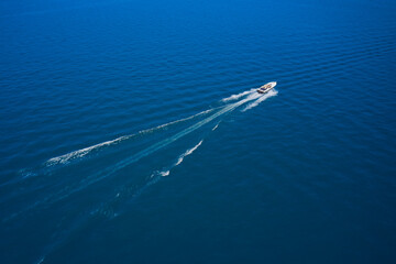 Aerial view luxury motor boat. Drone view of a boat  the blue clear waters. Travel - image. Large speed boat moving at high speed side view.