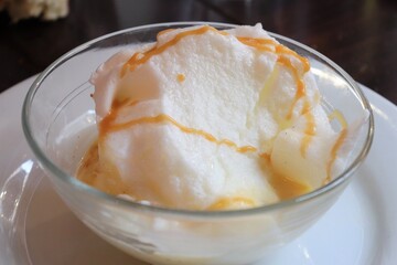 Ile flottante, ou oeufs à la neige dans un bol transparent sur une assiette blanche, dessert composé de blancs d'oeufs fouettés et de crême anglaise, ville de Lyon, département du Rhône, France