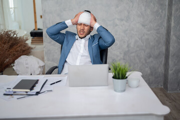Stressed businessman with palm on face in his office