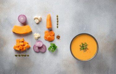 autumn pumpkin soup in dark bowl and ingredients for cooking. Vegetarian food. food knolling. flat...