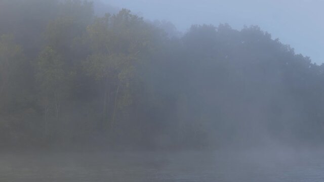 Foggy morning before sunrise on the Norfork river near Mountain Home Arkansas USA panning down and right