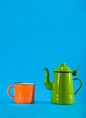 Vintage teacup and orange cup on blue background