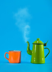 Vintage teacup and orange cup on blue background