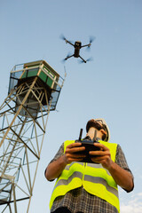 Drone operator piloting a drone next to a tower © Jordi Salas