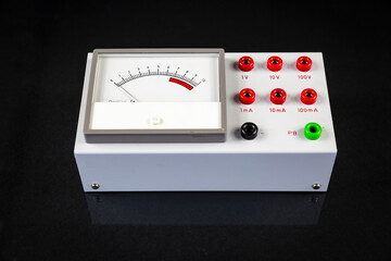 an analog multimeter - voltmeter and ammeter isolated on a black background