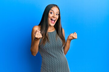 Young hispanic woman wearing casual clothes celebrating surprised and amazed for success with arms raised and open eyes. winner concept.