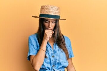 Young hispanic woman wearing summer hat feeling unwell and coughing as symptom for cold or...