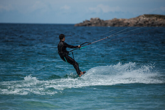 A man is pulled out of the water by his kite while kitesurfing