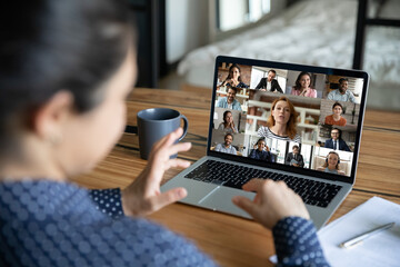 Rear view of woman brainstorm talk on team online video call with diverse multiracial colleagues....