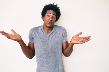 Handsome african american man with afro hair wearing casual clothes clueless and confused with open...