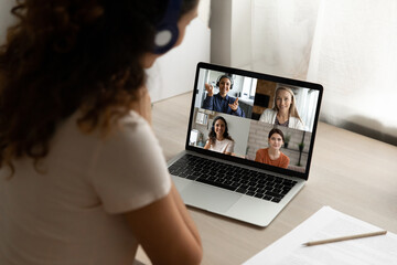 Close up rear view of woman look at laptop screen talk speak on video call with diverse girlfriends...