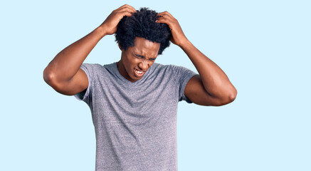 Handsome african american man with afro hair wearing casual clothes suffering from headache desperate and stressed because pain and migraine. hands on head.