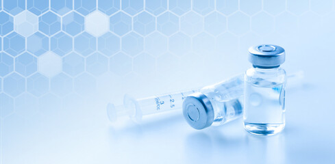 Medical syringe with a needle and a bollte with vaccine.