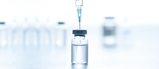 Medical syringe with a needle and a bollte with vaccine.