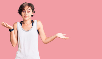 Beautiful young woman with short hair wearing casual sport clothes clueless and confused expression...