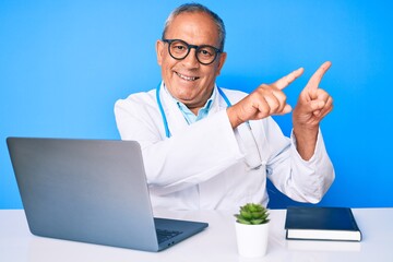 Senior handsome man with gray hair wearing doctor uniform working using computer laptop smiling and...
