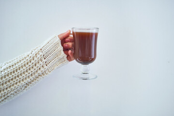 Female hands with cup of hot cocoa on a white background