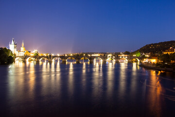 Fototapeta na wymiar Pargue charles bridge by night reflections river moving lights