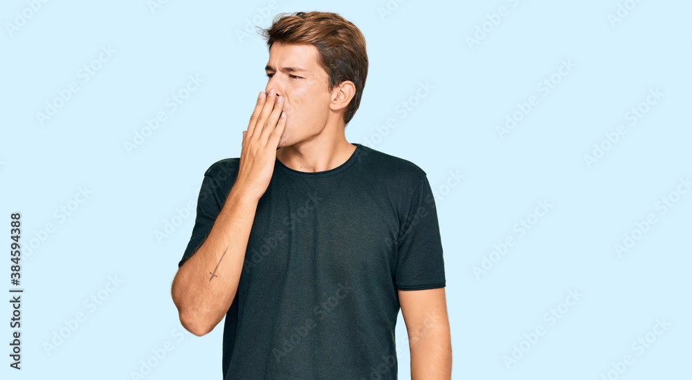 Wall mural Handsome caucasian man wearing casual clothes bored yawning tired covering mouth with hand. restless and sleepiness.