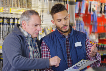 two men looking through catalogue in hardware store