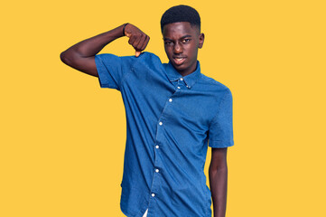 Young african american man wearing casual clothes strong person showing arm muscle, confident and proud of power