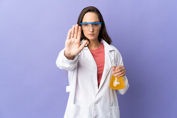 Young scientific woman over isolated background making stop gesture