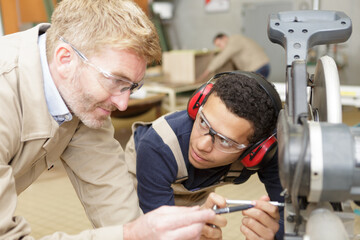 workers and apprentice wearing earmuffs