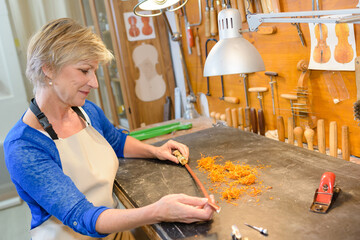 female luthier working on the creation of a violin