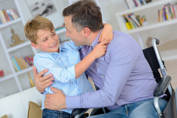 Fototapeta premium a man in a wheelchair with his son
