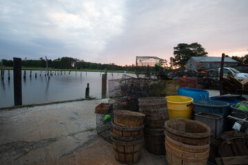 Crab pots and bushel baskets lined up at the waterfront ready for a day of crabbing in the...