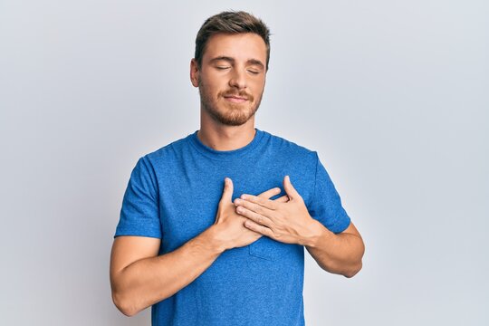 Handsome caucasian man wearing casual clothes smiling with hands on chest, eyes closed with grateful gesture on face. health concept.