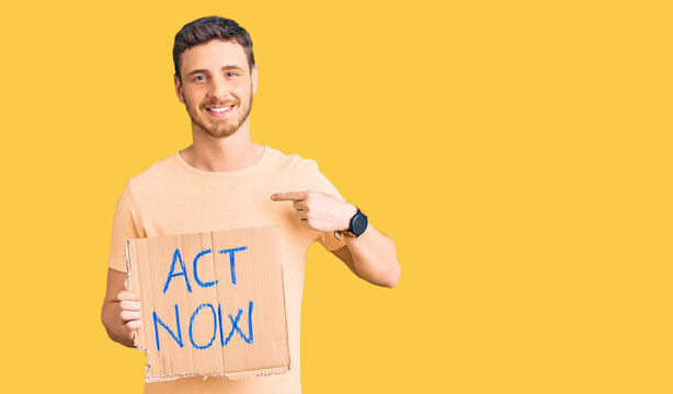 Handsome young man with bear holding act now banner pointing finger to one self smiling happy and proud