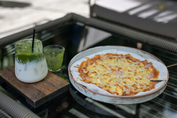 whole italian pizza with ice green tea on wood table with ingredients.