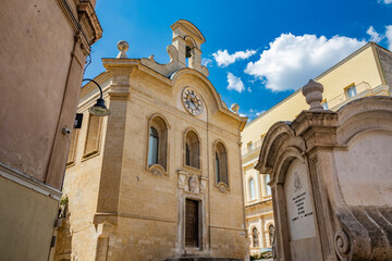 Fototapeta premium Gravina in Puglia, Italy. A glimpse of the main square of the ancient city, overlooked by the library. The large fountain in the center.