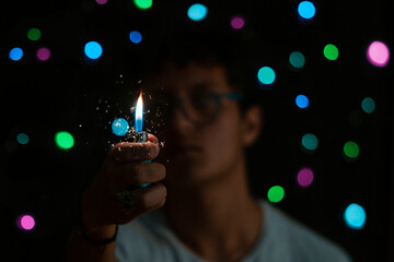 person holding a lighter with bokeh lights as background