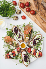 sandwich near by wooden board quail eggs and tomatoes